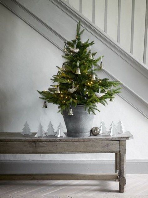 small tree with bell and bird ornaments in a galvanized bucket