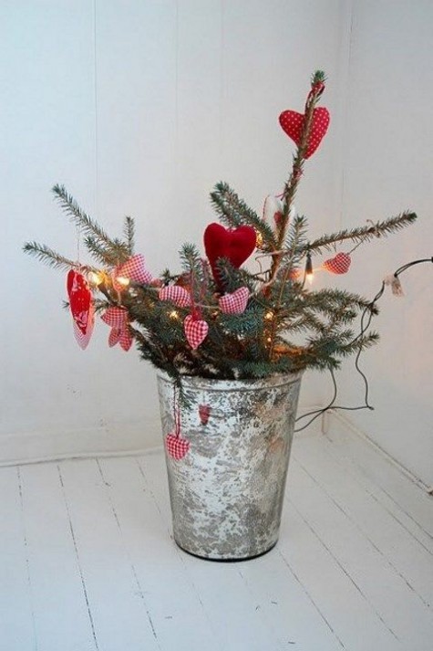 evergreen branches in a bucket, red heart ornaments