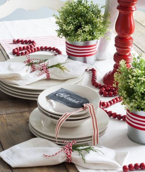 potted greenery, a cranberry garland, red and white ribbon and yarn