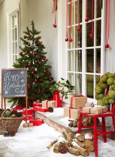 red gift boxes, red ornaments hanging and a green wreath and tree