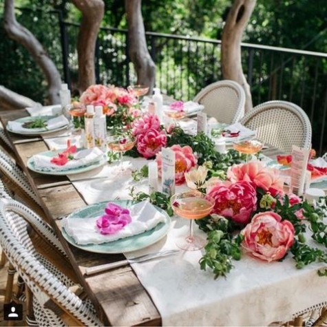 a creamy table runner, blue plates and a bold flower and greenery table runner
