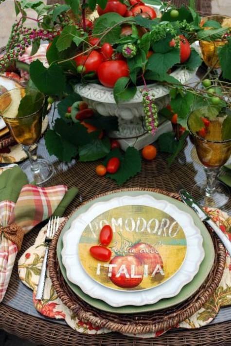 a tomato and leaf centerpiece, wicker chargers and printed plates