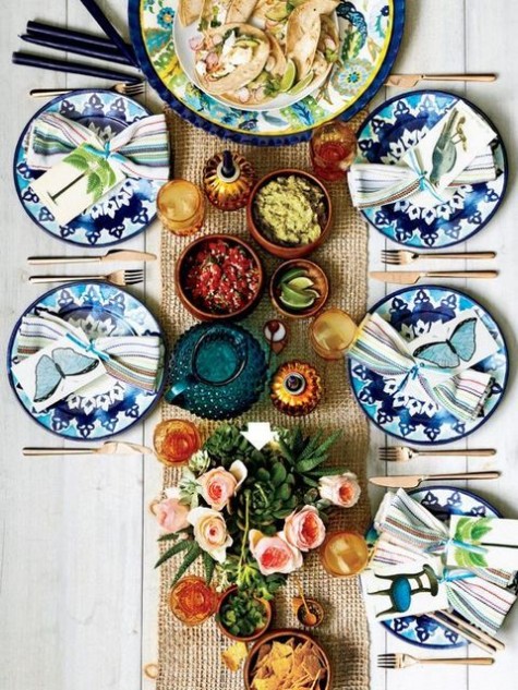 blue printed plates, a burlap table runner and colorful glasses