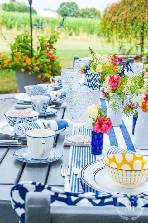 cobalt blue printed table runner, napkins and tableware, bold yellow and pink flowers
