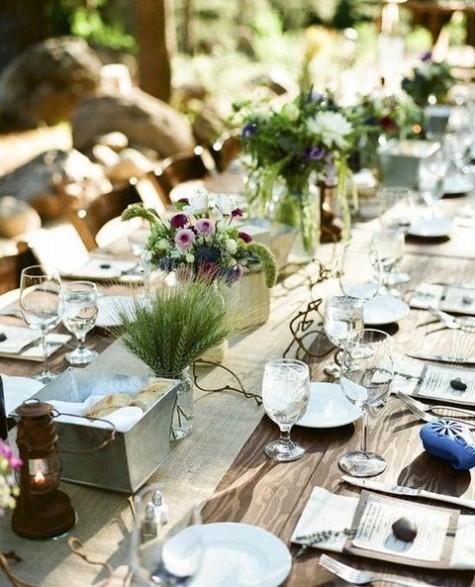 inviting table setting with simple floral centerpieces and a burlap table runner