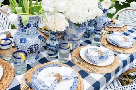 large blue and white vases with white florals, rattan chargers and blue printed plates