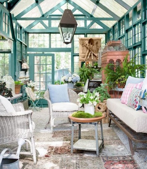 a former greenhouse with wicker furniture and lots of potted greenery to have a rest