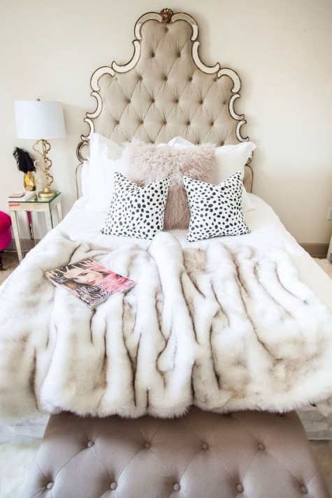 a refined upholstered headboard, a faux fur bedspread and a pink pillow to add glam