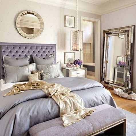 lavender-colored and ivory bedroom with a refined mirror, an upholstered lavender bench, a tufted upholstered headboard and a mirror