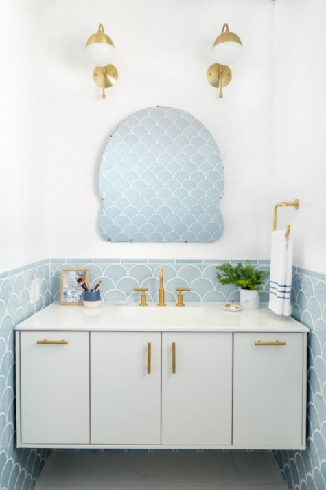 powder room with blue fishscale tiles and brass accents