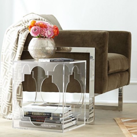 a carved acrylic side table is used for storage, too