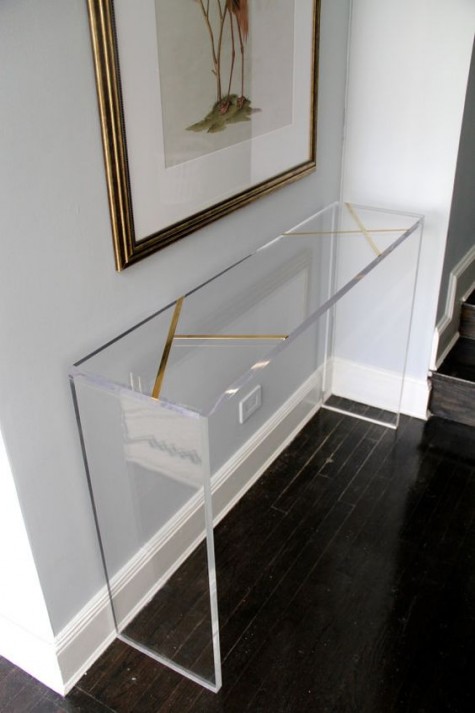 a clear acrylic console with gold stripes for more chic