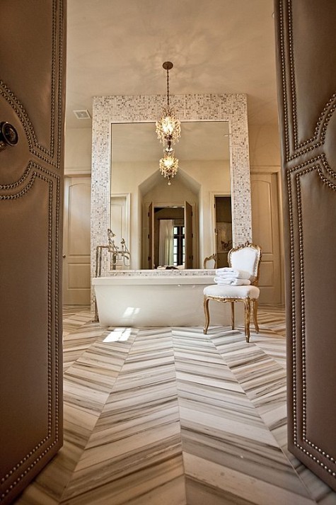 a luxurious bathroom with a large mirror in mosaic tile framing