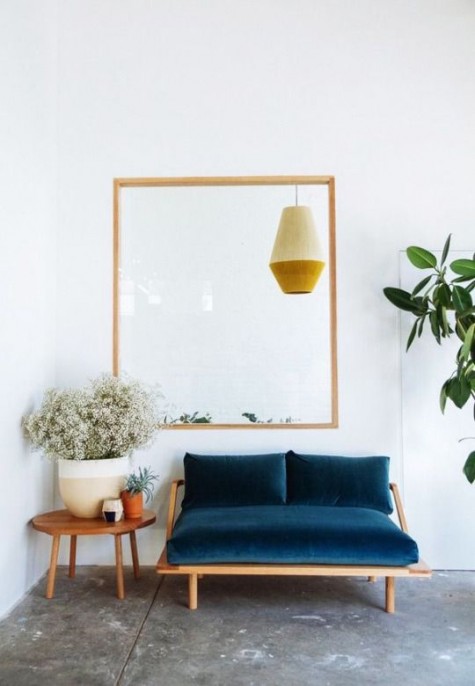 a navy velvet loveseat with a mid-century feel