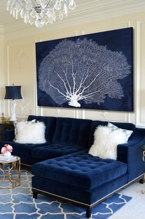 a navy velvet sectional sofa and a gorgeous statement artwork for a seaside space
