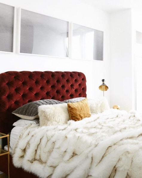 a red velvet upholstered bed with dimaond upholstery and a faux fur cover