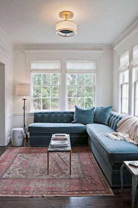 a sectional blue velvet sofa in a living room
