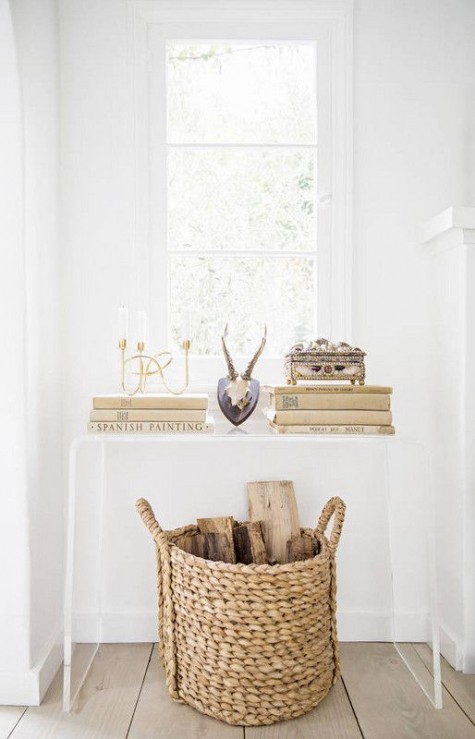 a sheer console with books and firewood in a basket under it