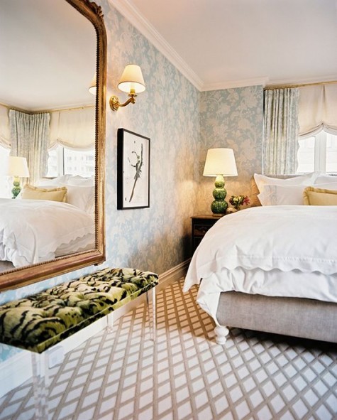an oversized vintage mirror on the wall and a lucite bench