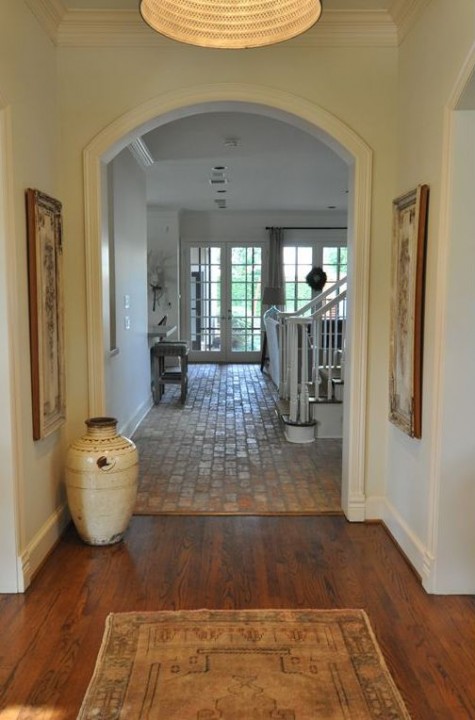 brick floors in the entryway and wooden ones separated with a small line