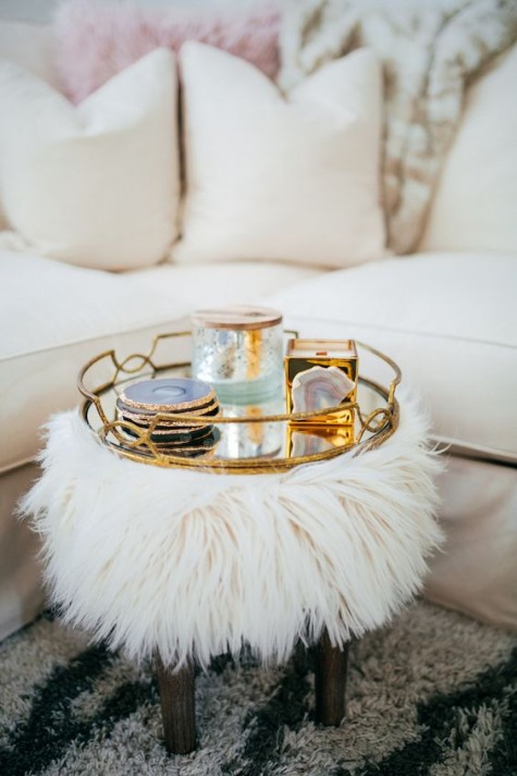 a fau fur ottoman on wooden legs will add a glam feel