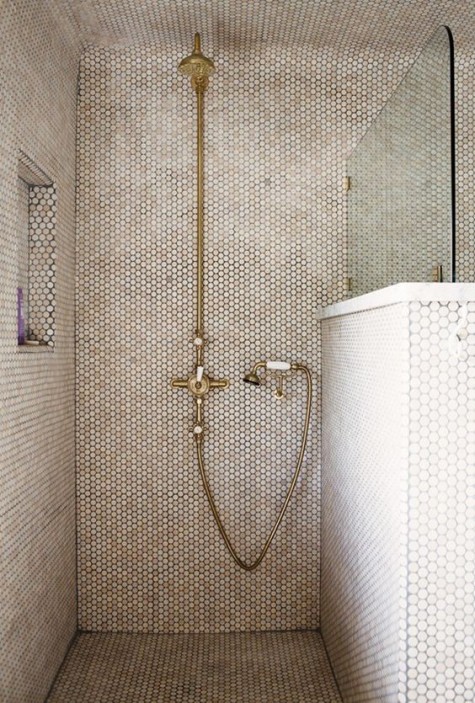 creamy pennty tiles on the shower with copper fixtures