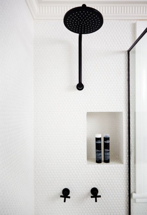 white penny tiles in the shower with black fixtures