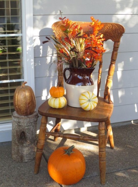a chair display with pumpkins_ wheat and fall leaves