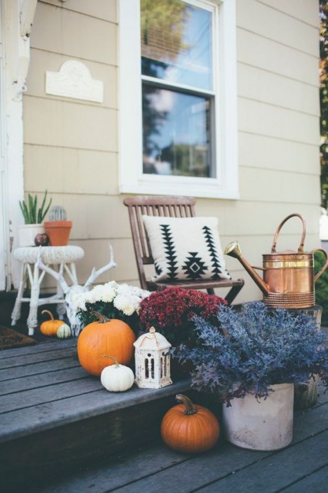 a chic porch with white_ purple_ burgundy blooms and orange and white pumpkins