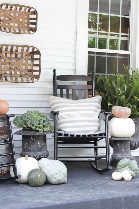 a rocking chair with neutral pumpkins and gourds and some veggies