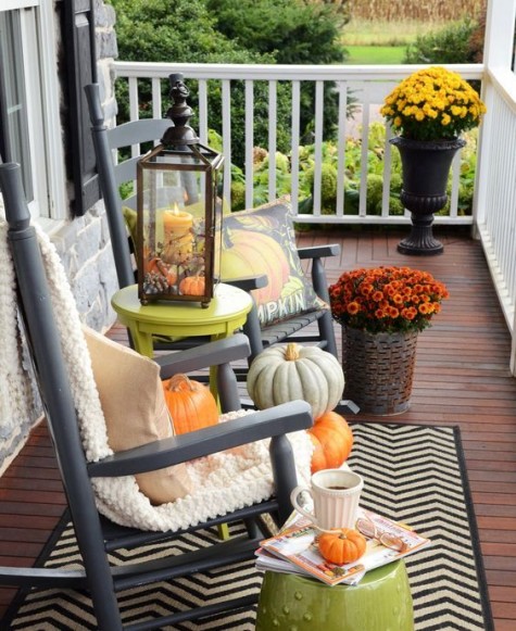 two rocking chairs with knit covers_ pumpkins and potted fall blooms
