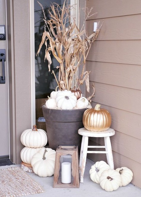 white and metallic pumpkins_ corn husks_ a wooden lantern and a white stool