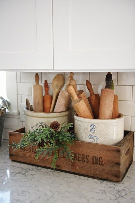 a crate with evergreens and pinecones for a winter feel