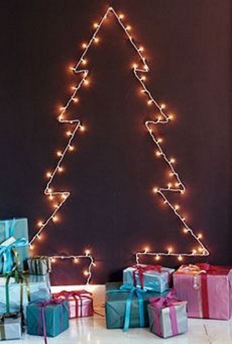 a lights Christmas tree on a chalkboard wall