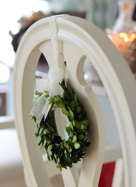 a tiny box wood wreath with white ribbon on the chair