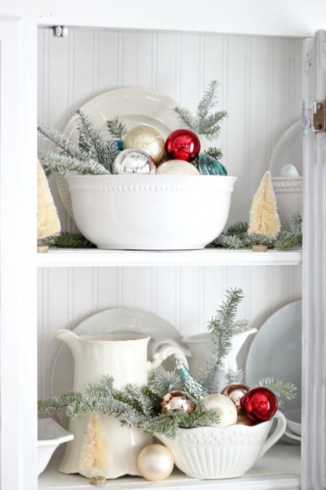 place faux fir branches and Christmas ornaments into bowls