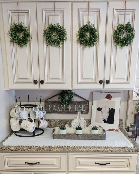 small greenery wreaths on the cabinets and on the wall