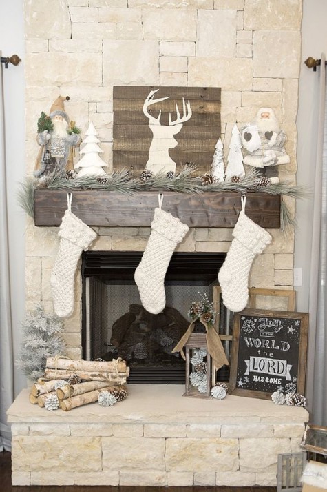a pallet deer sign, Santa Claus figurines and an evergreen garland with pinecones