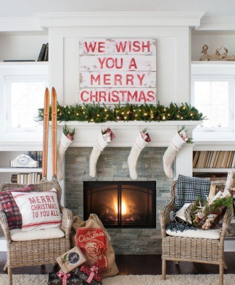 a pallet sign, a lush evergreen garland with lights and stockings