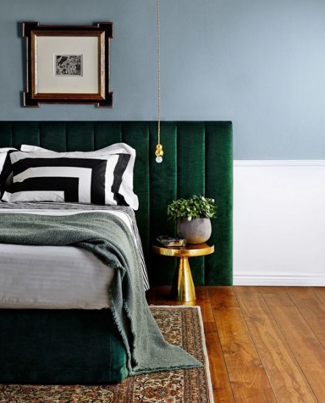 an emerald velvet padded headboard and brass accents