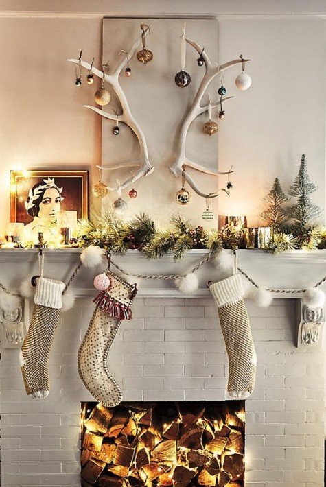 an evergreen garland with lights and antlers with ornaments