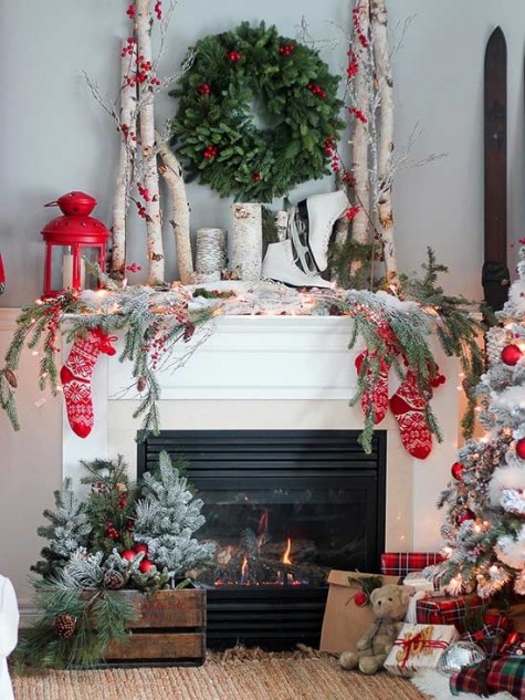 birch branches, a lit up evergreen garland, red socks, berries and lanterns