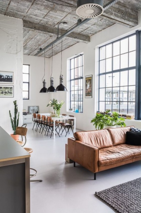 a brown leather sofa that serves as a space divider