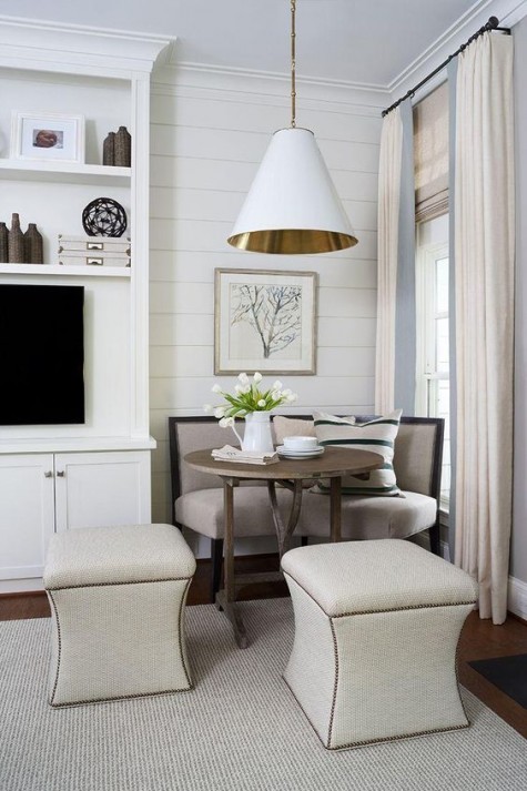 a comfy nook with a rounded upholstered bench and a rustic table