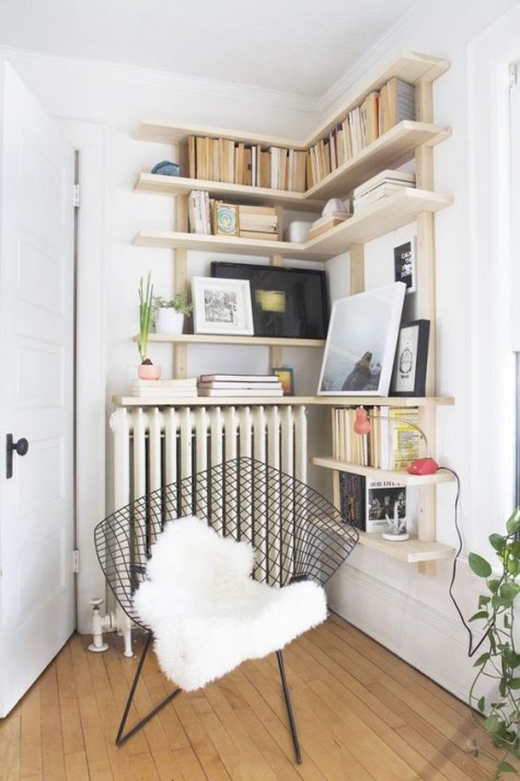a cozy reading nook with shelves and a modern chair with a fur cover