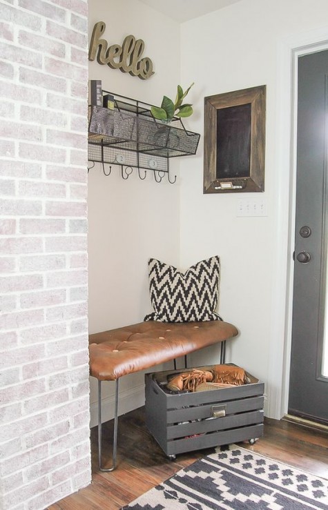 a leather bench with hairpin legs in a small nook and a crate for storage