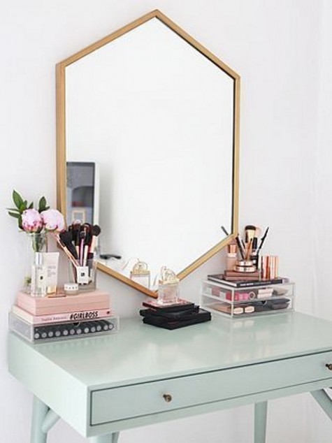 a mid-century modern space with a geometric mirror and a light green vanity