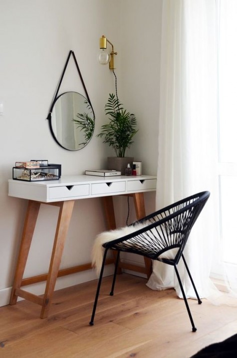 a mid-century modern vanity, a suspended lamp and mirror and a comfy chair