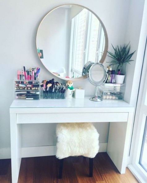 a simple makeup nook with a couple of mirrors, a faux fur stool and acrylic makeup storage