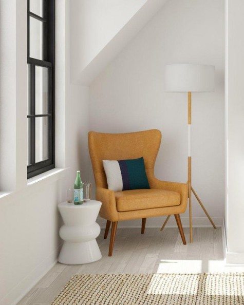 a small reading nook with a chair, a lamp and a small side table